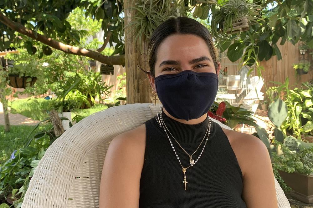 Claudia Guerra, who was born in Cuba but grew up in Miami, sits in her grandparents' backyard.