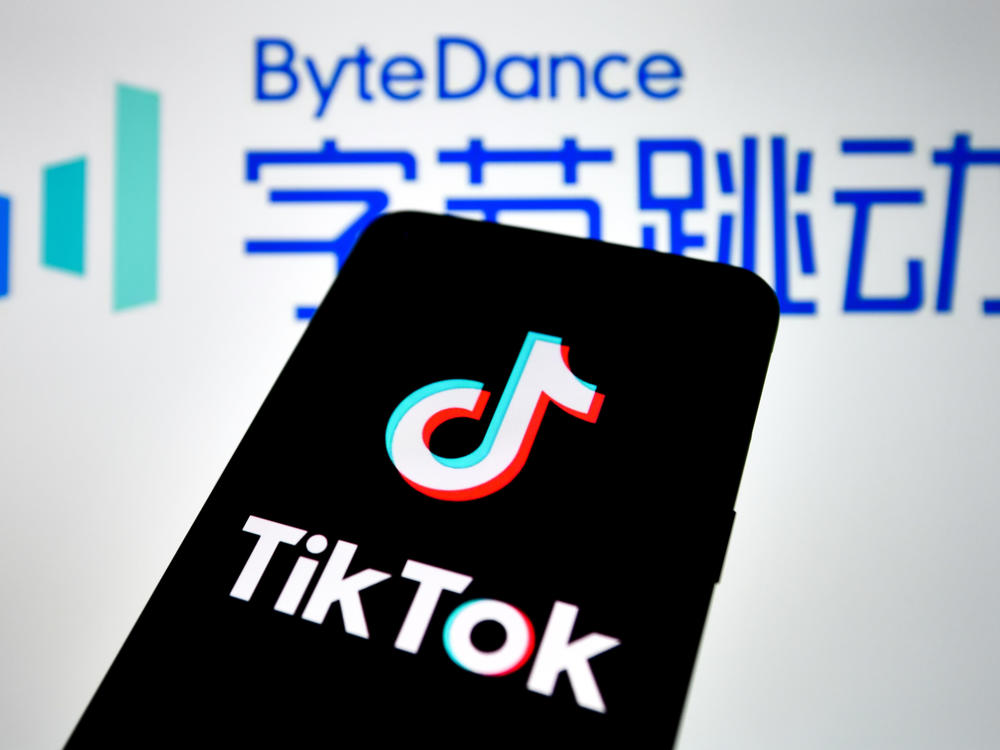 In this photo illustration, a TikTok logo seen displayed on a smartphone with a ByteDance logo picture in the background.