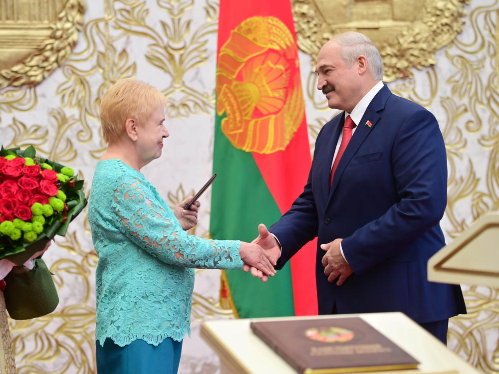 Lidia Yermoshina (left), chairperson of the Belarusian Central Election Commission, hands over a presidential ID to President Alexander Lukashenko during an inauguration ceremony Wednesday at Independence Palace in Minsk.