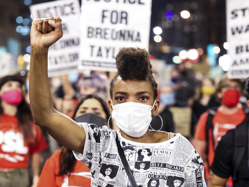 Sheree Barbour holds her fist in the air in Denver, Colo. as people protest the grand jury decision in the Breonna Taylor case.