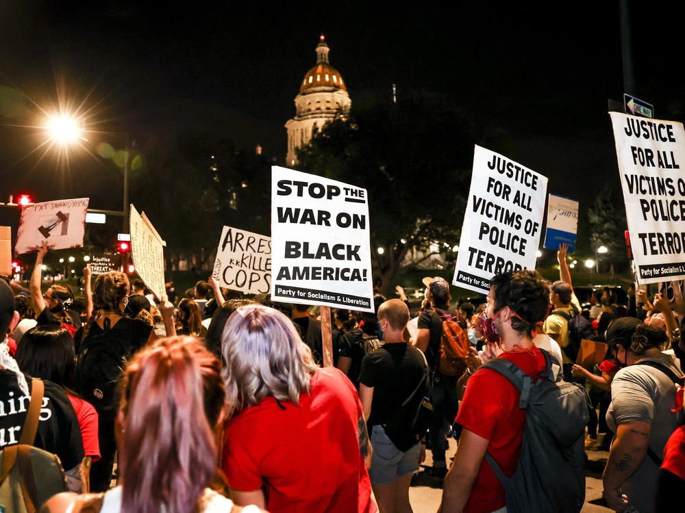 People protest the grand jury decision in the Breonna Taylor case in front of the Colorado state Capitol in Denver on Wednesday. As the protest was breaking up, a motorist drove through a small crowd of protesters who had yelled at the driver to turn around.