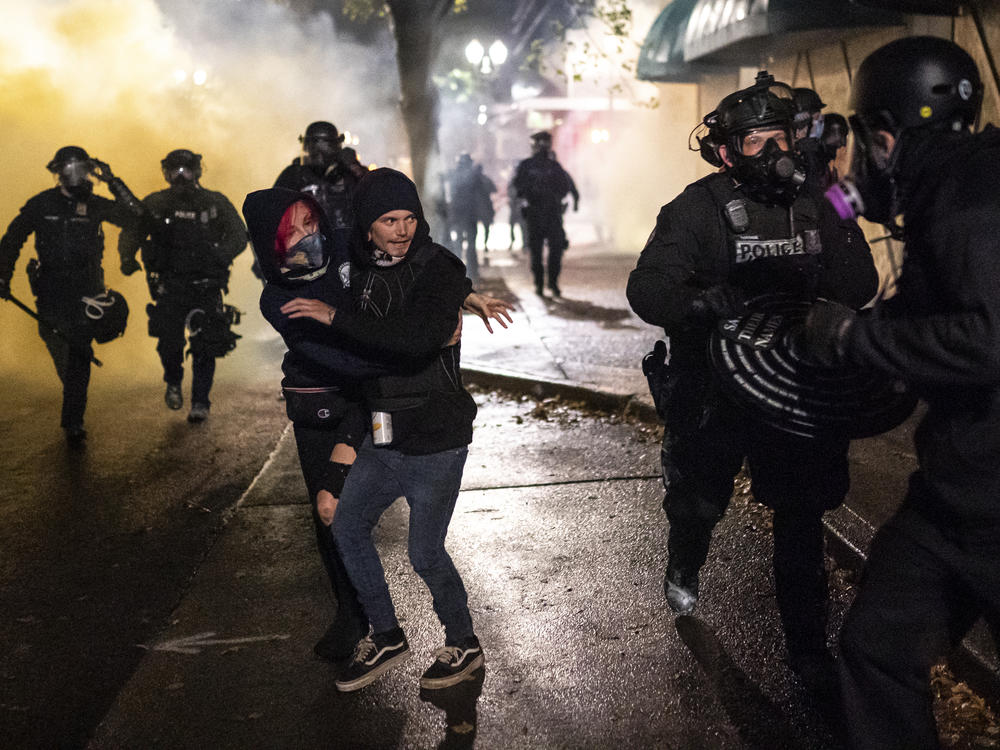 Protesters look for an escape while Portland police disperse a crowd in Portland, Ore. Wednesday. Violent protests erupted following the results of a grand jury investigation into the police shooting death of Breonna Taylor.