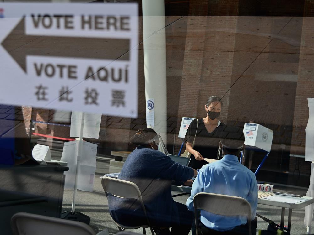 Many people who normally take on jobs as poll workers are in higher-risk groups for the coronavirus, leading to fears of a widespread shortage of poll workers. Here, New York City Board of Election employees and volunteers help voters at the Brooklyn Museum polling site during the New York Democratic presidential primary in June.