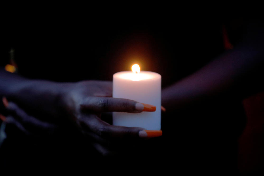 A woman holds a candle at a 
