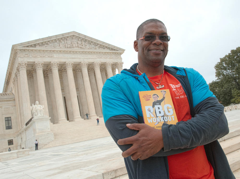Bryant Johnson, who was Justice Ruth Bader Ginsburg's personal trainer, poses at the court in 2017 with his book, 
