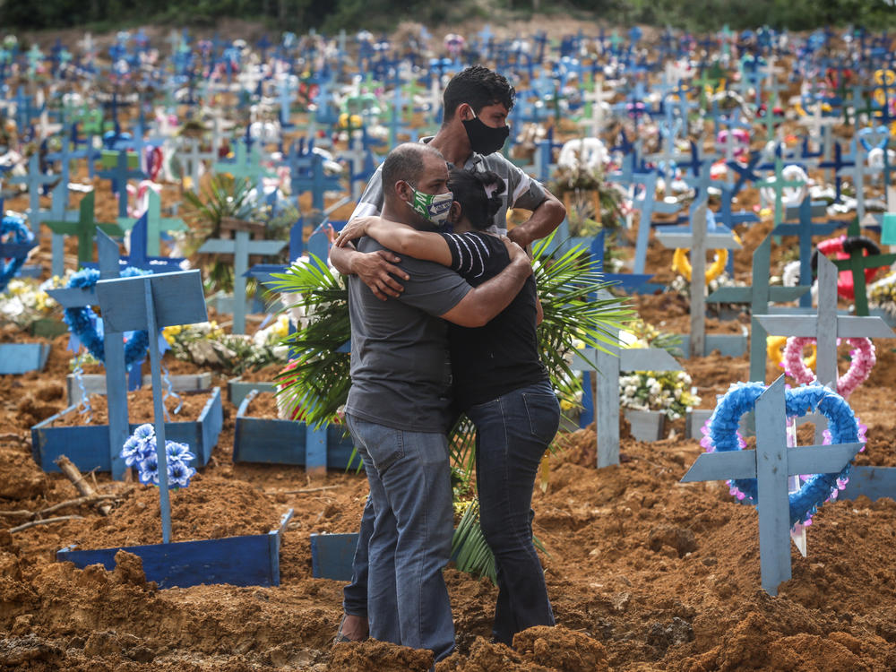 Relatives at a mass burial of pandemic victims at the Parque Taruma cemetery in Manaus, Brazil, mourn a family member.