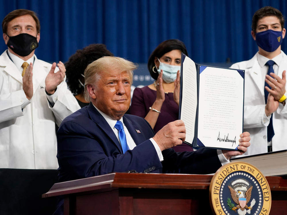 President Trump holds up an executive order after delivering remarks on health care in Charlotte, N.C., on Thursday.