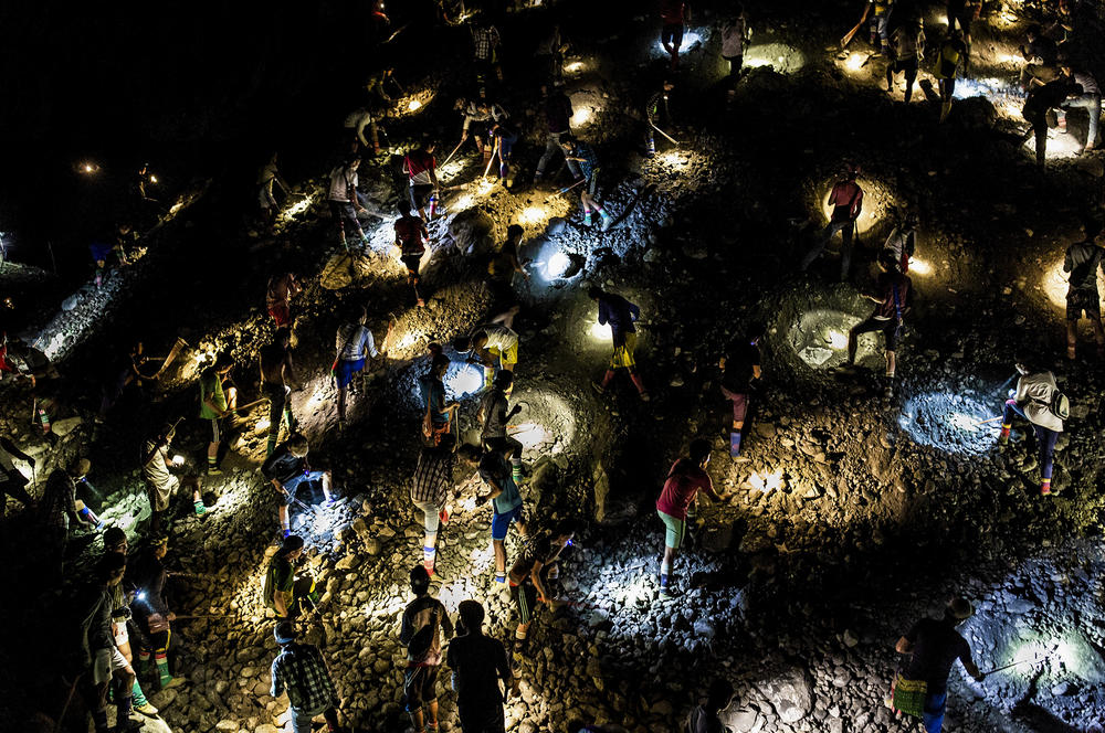 Freelance miners use flashlights to search for jade at night, during company off-hours, in Hpakant in 2019.