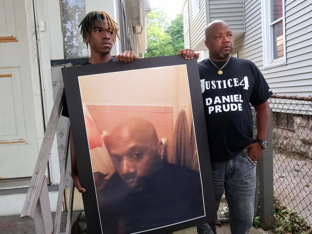 Family members Armin Prude (left) and Joe Prude stand with a picture of Daniel Prude in Rochester, N.Y., Thursday, Sept. 3, 2020. While suffering a mental health crisis, Prude, 41, suffocated after police in Rochester put a 