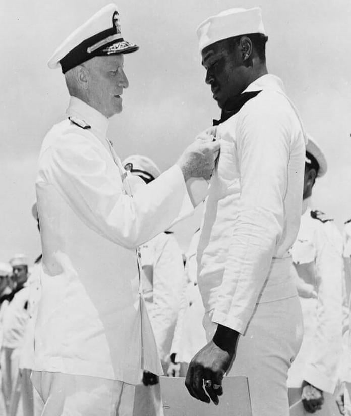 Miller receives the Navy Cross from Adm. Chester Nimitz, commander of the U.S. Pacific Fleet, during a ceremony on board the USS Enterprise on May 27, 1942.