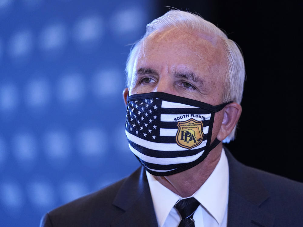 Miami-Dade County Mayor Carlos Gimenez speaks with the news media, last month, at Hard Rock Stadium in Miami Gardens, Fla. Gimenez said Tuesday that he would keep some COVID-19 restrictions in place despite an order by Fla. Gov. Ron DeSantis.
