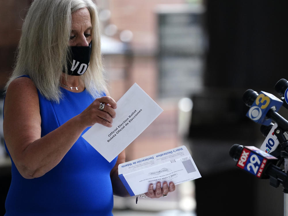Philadelphia City Commissioner Lisa Deeley opens a sample mail-in ballot during a news conference at the opening of a satellite election office at Temple University's Liacouras Center on Sept. 29 in Philadelphia.