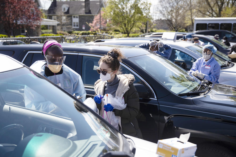 Stanford, left, assisted by medical student Tal Lee, prepares to administer a coronavirus swab test on a person in the parking lot of Pinn Memorial Baptist Church in Philadelphia on April 22.