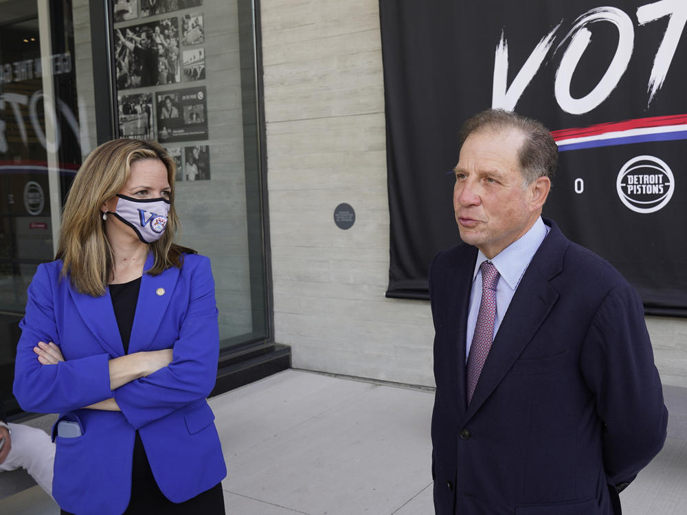 Michigan Secretary of State Jocelyn Benson (left) and Detroit Pistons Vice Chairman Arn Tellem talk about voting last Thursday, when balloting began in the state. The Pistons are allowing their arena to be used as a polling station.