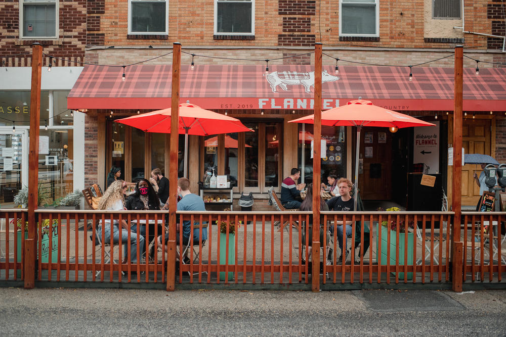 Customers sit and eat in a converted parking spot outside of Flannel, a restaurant in Philadelphia.