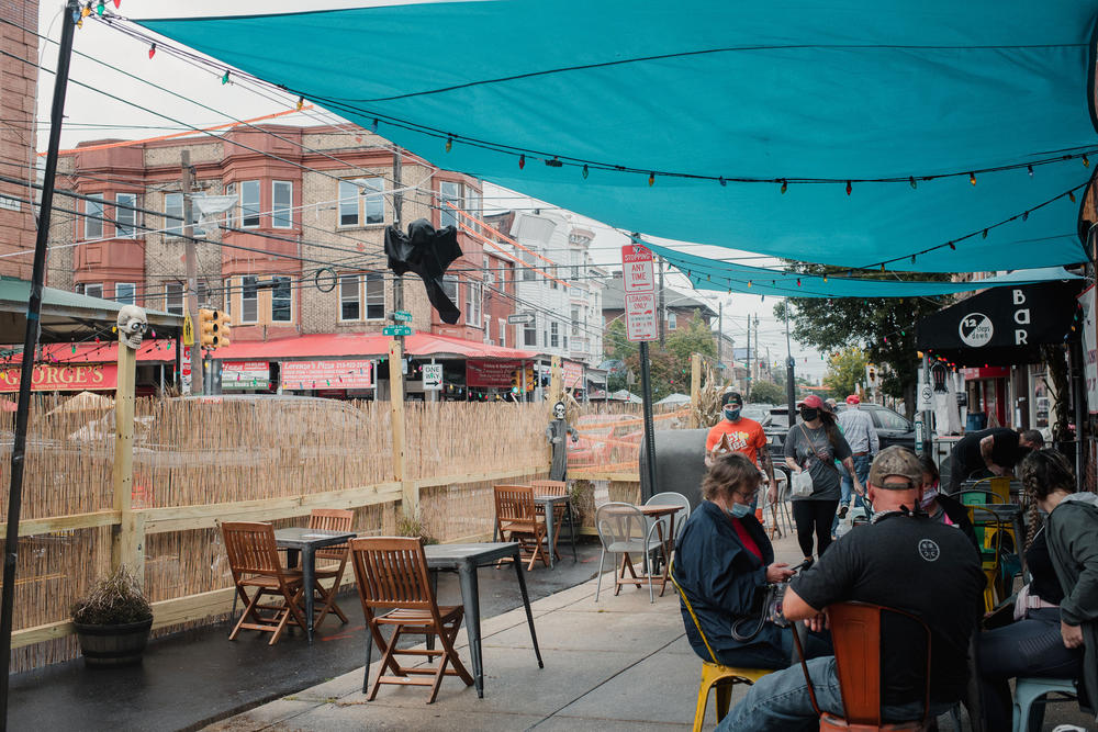 At the 12 Steps Down Bar, two parking spaces are blocked off with wooden barriers, tall reeds and strings of lights.