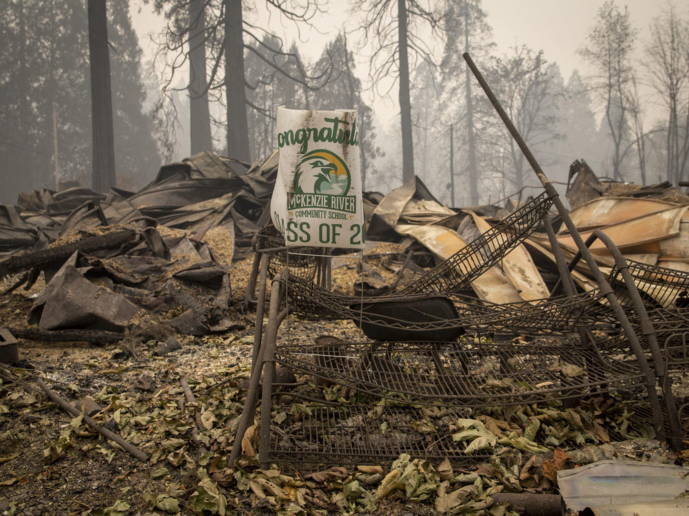 A sign for a recent graduate is bent but not burned in Blue River, Ore., eight days after the Holiday Farm Fire swept through its business district.