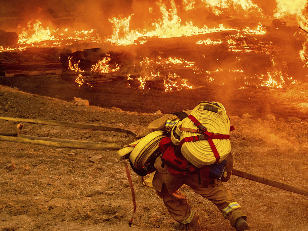A firefighter battles the Glass Fire in Napa Valley, Calif., on Thursday.