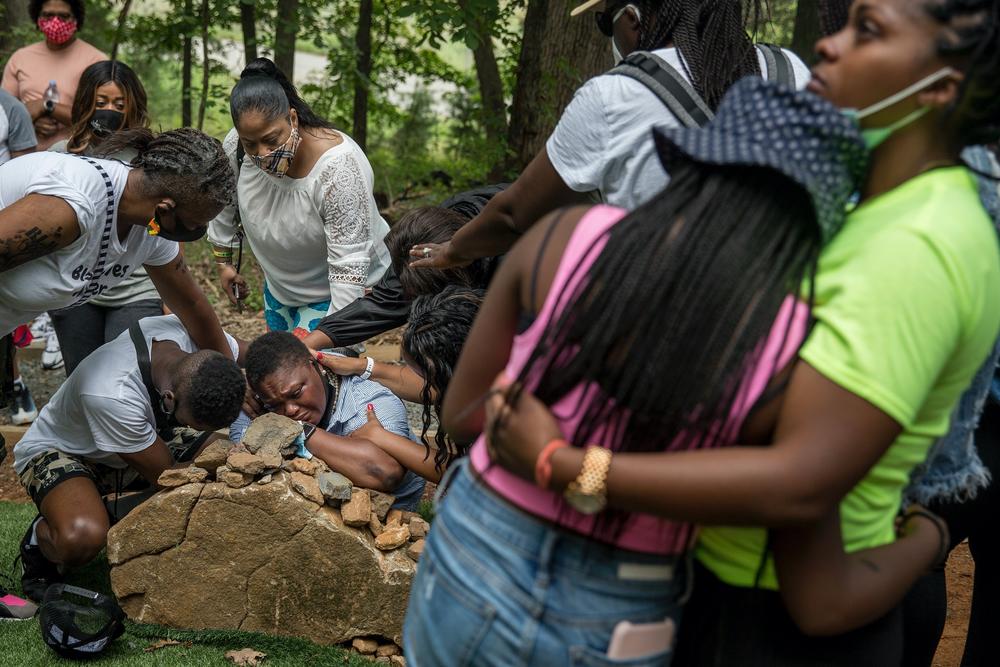 Surrounded by loved ones, Pastor Michelle Thomas grieves at the stone marking her son's grave at the African American Burial Ground for the Enslaved at Belmont. Her son, Fitz Alexander Campbell Thomas, 16, died in June and is the first free African American to be buried at the site.