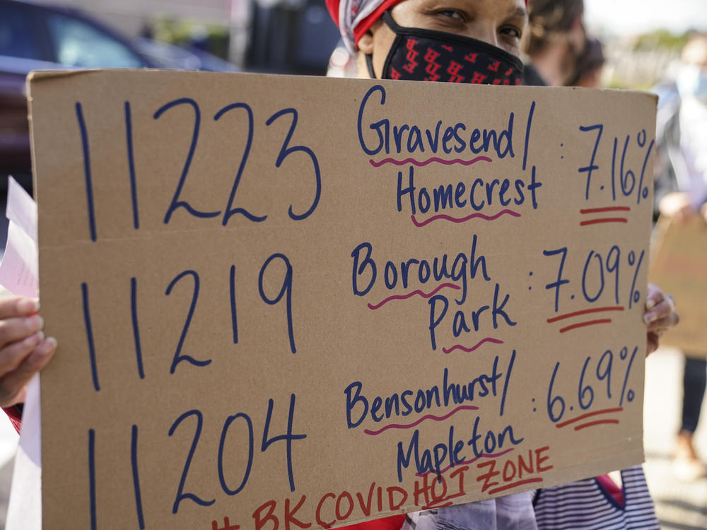 Teachers and staff protest outside Franklin D. Roosevelt High School as they call for more and better COVID-19 testing and precautions on Friday in New York City. The ZIP codes listed on this sign are among those soon to face restrictions by the city.
