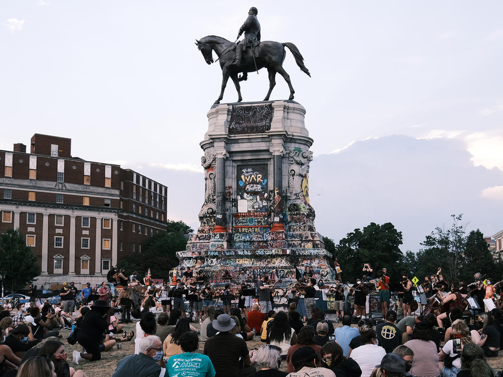 Hundreds of people gather at the Robert E. Lee monument in Richmond, Va., in July. The Mellon Foundation says it will spend $250 million over five years to re-imagine commemorative spaces in the U.S.