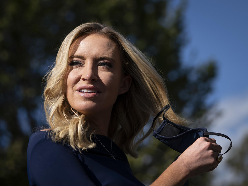 White House press secretary Kayleigh McEnany takes off her face covering before speaking with reporters outside the West Wing of the White House on Friday, the day President Trump announced he had tested positive for the virus.