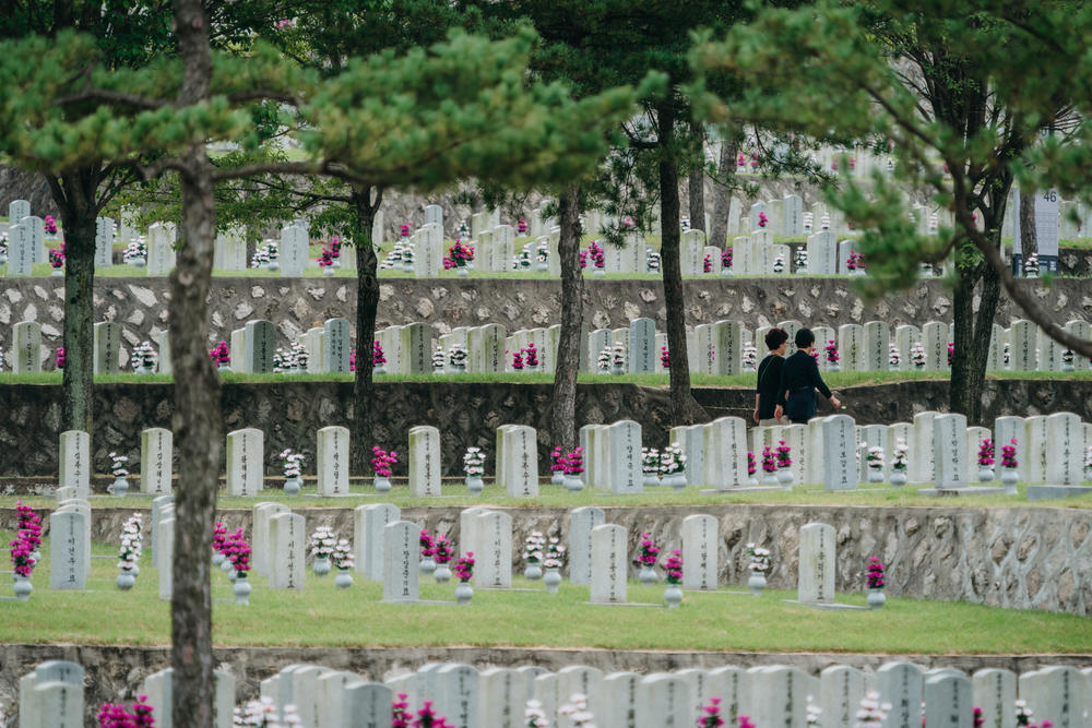 Visitors walk across a graveyard at the Seoul National Cemetery last week.