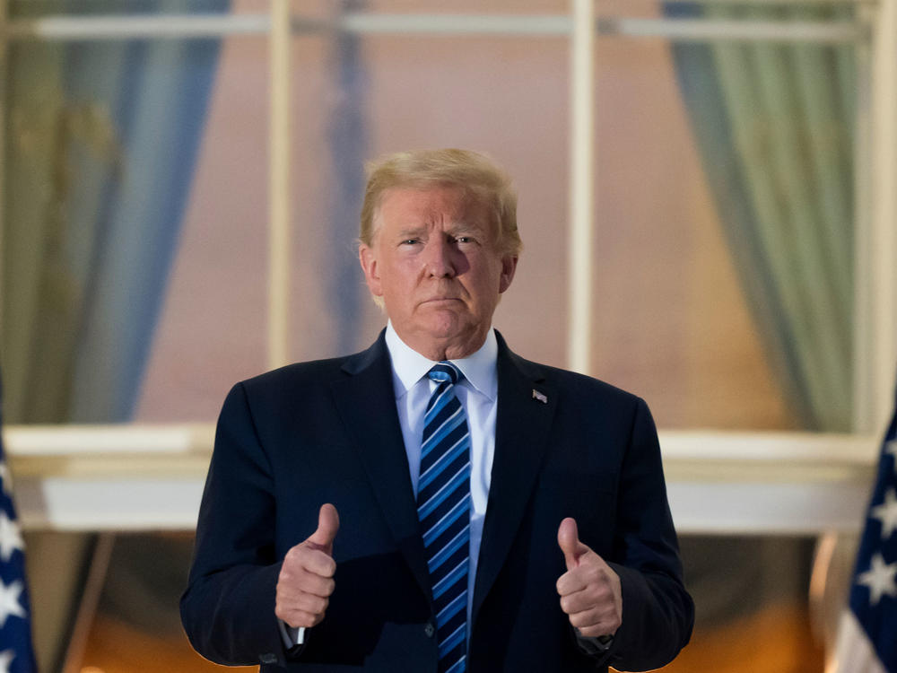President Donald Trump gives thumbs up as he stands on the Blue Room Balcony upon returning to the White House on Monday.