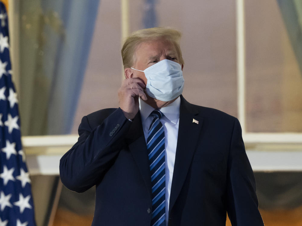 President Trump removes his mask upon returning to the White House on Monday after undergoing treatment for COVID-19 at Walter Reed National Military Medical Center in Bethesda, Md.