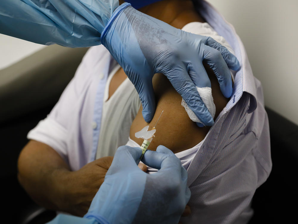 A volunteer in a clinical trial for an experimental COVID-19 vaccine receives an injection last month at Research Centers of America in Hollywood, Fla.