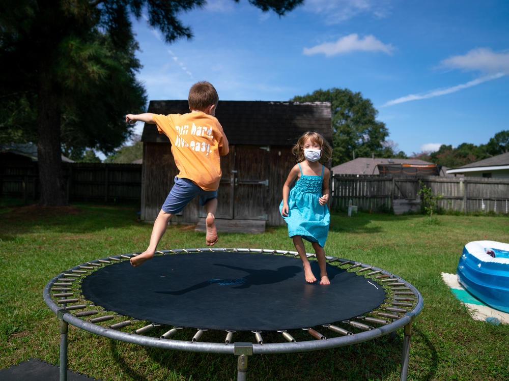 Lachlan (left) and Lillian Barilleau play in the backyard of their home in Central, La. They were displaced from the house for months after a flood in 2016.