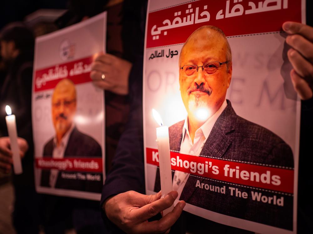 People hold posters picturing Saudi journalist Jamal Khashoggi and lit candles during a gathering outside Saudi Arabia's Consulate in Istanbul, on Oct. 25, 2018.