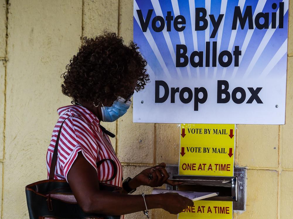 A woman drops her ballot by mail at Broward County Supervisor Of Elections Office in Lauderhill, Fla., on Monday.
