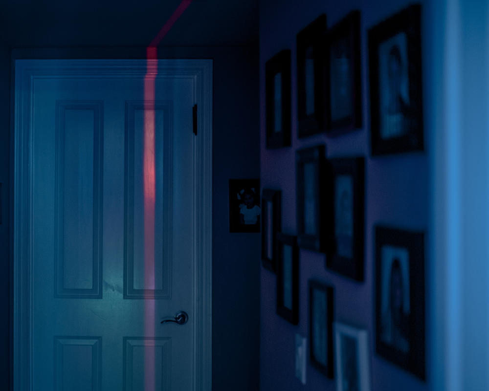 Red and blue hues spill onto Imma's bedroom door from her younger daughter's LED lights on May 10.