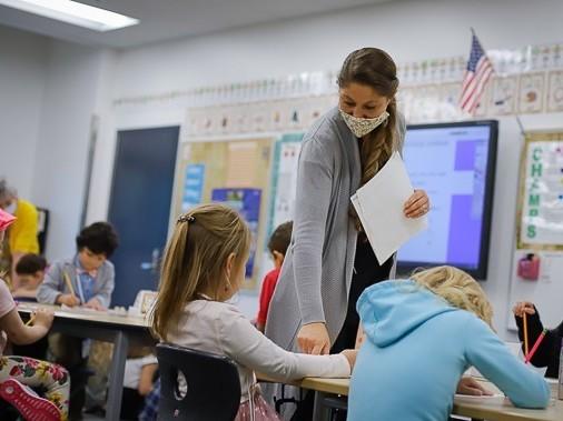 Public school teacher Kelly Mrozik holds in-person class for first graders in Wasilla, Alaska. She is required to wear a mask. Her students are not.