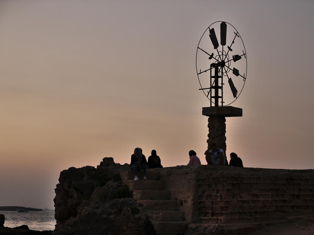 Relatives of Mohammed Khaldoun sit next to a windmill in Tripoli, Lebanon, as they pray for his safe return home last month. Khaldoun, 27, was missing at sea after he tried to reach Cyprus on an overcrowded boat.