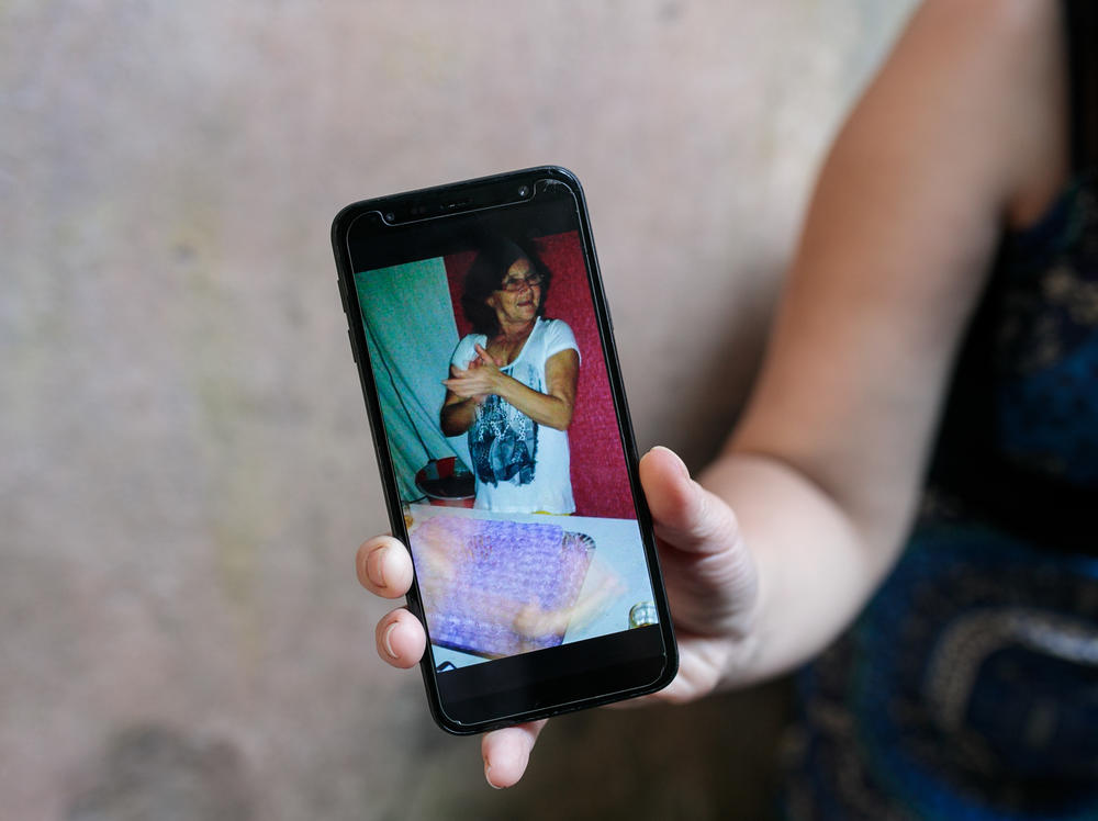 Fernandes de Andrade shows a photograph of her mother, who died from COVID-19 in April.