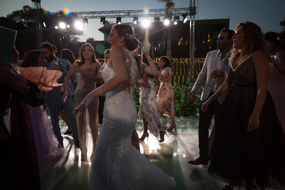 Dina el-Harazy, center, dances at her wedding reception in Cairo. The wedding was rescheduled three times because of coronavirus restrictions.