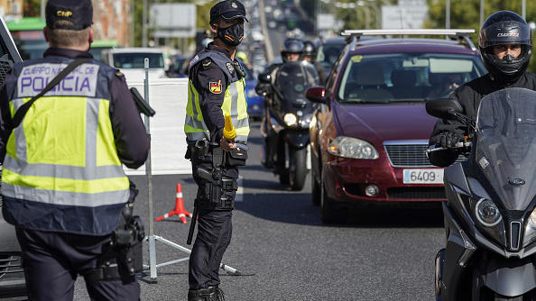 Police officers man a roadside checkpoint in Madrid Friday as travel restrictions are imposed to cope with a new wave of coronavirus infections.