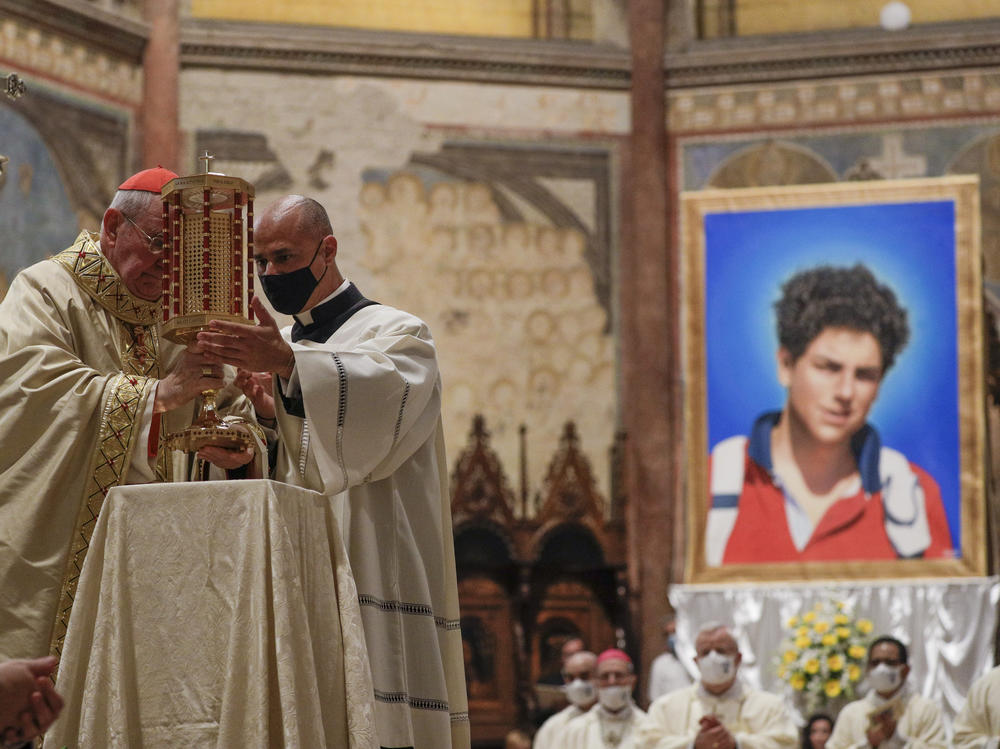 Cardinal Agostino Vallini, left, holds a relic of 15-year-old Carlo Acutis, an Italian boy who died in 2006 of leukemia, during his beatification ceremony celebrated in the St. Francis Basilica, in Assisi, Italy, on Saturday.