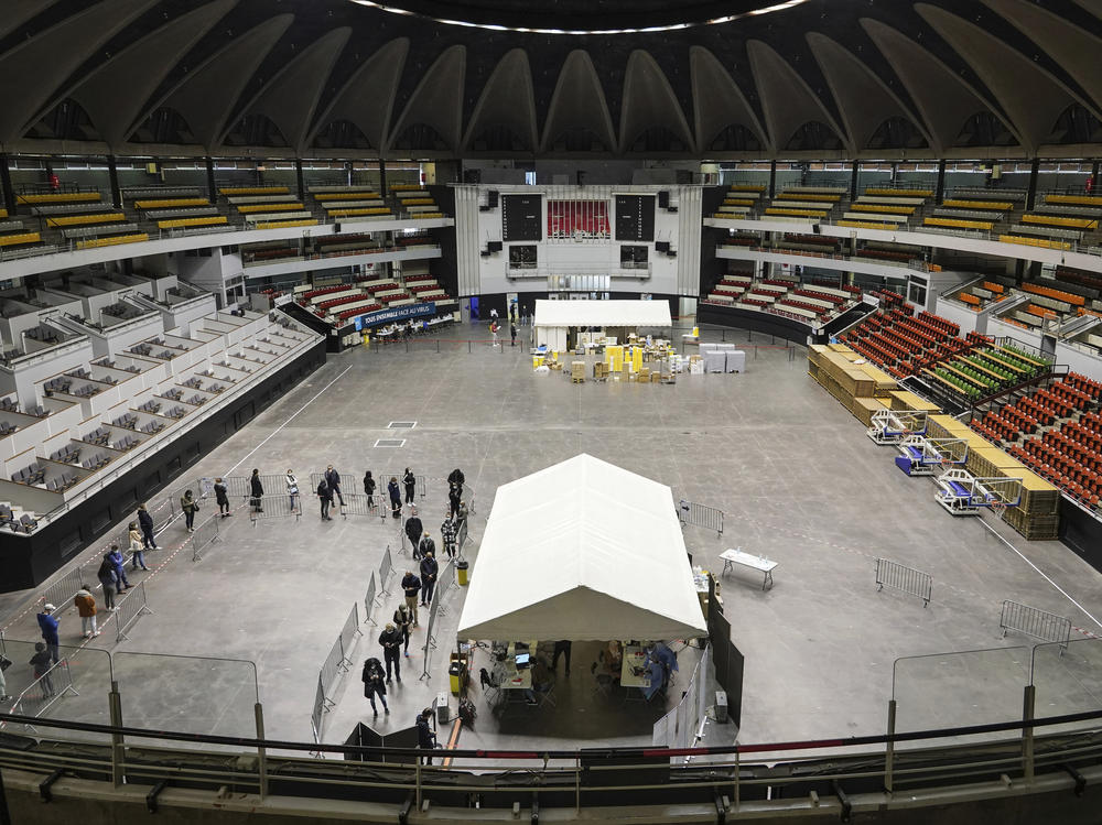 People queue to be tested for the coronavirus in a sports arena on Tuesday in Lyon, France. The World Health Organization said there were more than 700,000 new coronavirus cases reported in Europe last week.