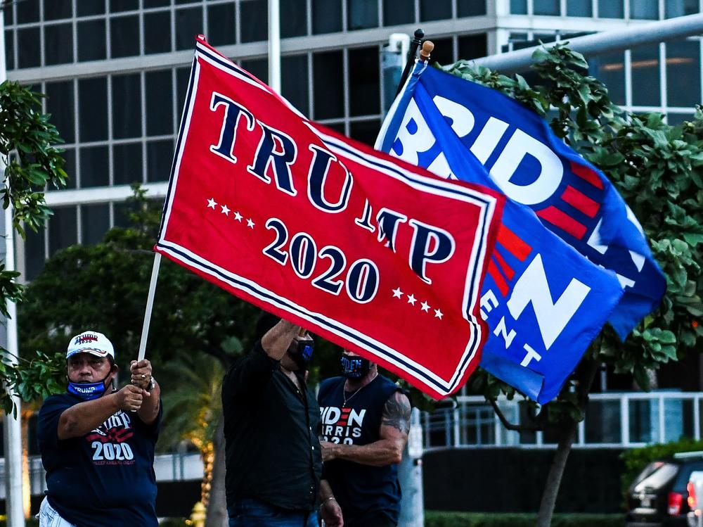 Supporters of President Trump and Democratic presidential nominee Joe Biden wave flags prior to Biden's arrival for a town hall in Miami.