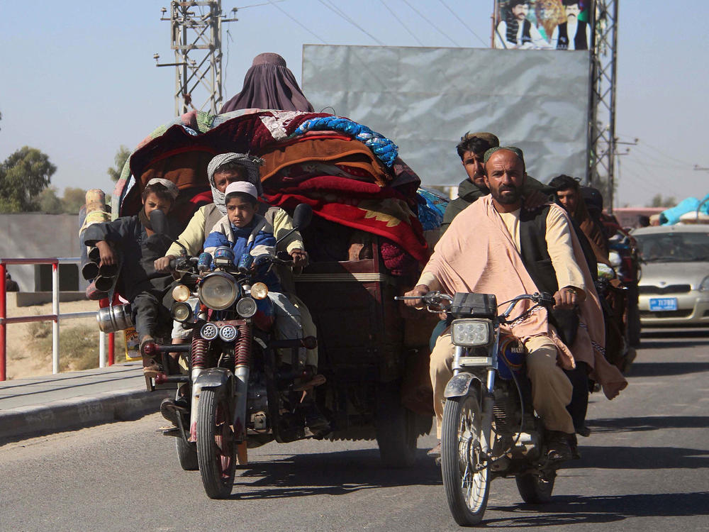 Afghans flee to Lashkar Gah, Helmand's provincial capital, during fighting between Taliban and Afghan security forces on Monday. Local authorities estimate that some 35,000 people have been displaced into Lashkar Gah since a Taliban offensive began in Helmand.