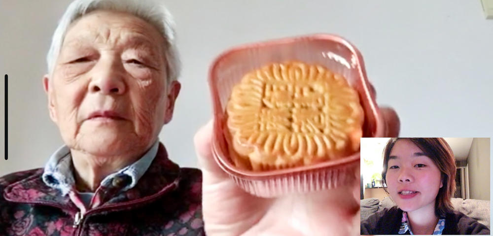 Nai holds a mooncake — a Chinese treat — up to the camera for her granddaughter.