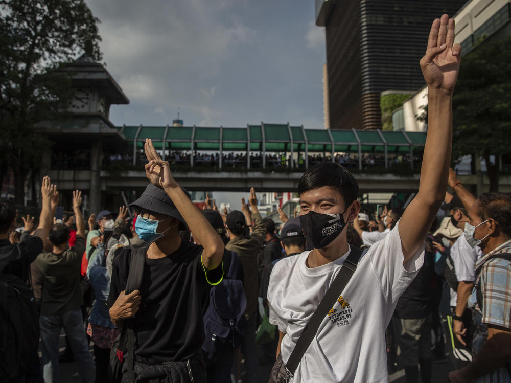 Pro-democracy protesters hold up a three-fingered salute Thursday at Bangkok's Ratchaprasong intersection.