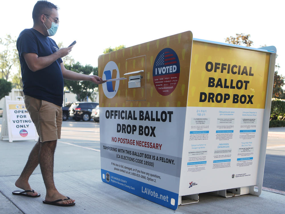 A voter places a ballot in an official mail-in ballot drop box outside the Los Angeles County Registrar's office this week in Norwalk, Calif. The California Republican Party has said it will not comply with a state cease-and-desist order to halt usage of the GOP's unofficial ballot drop boxes.