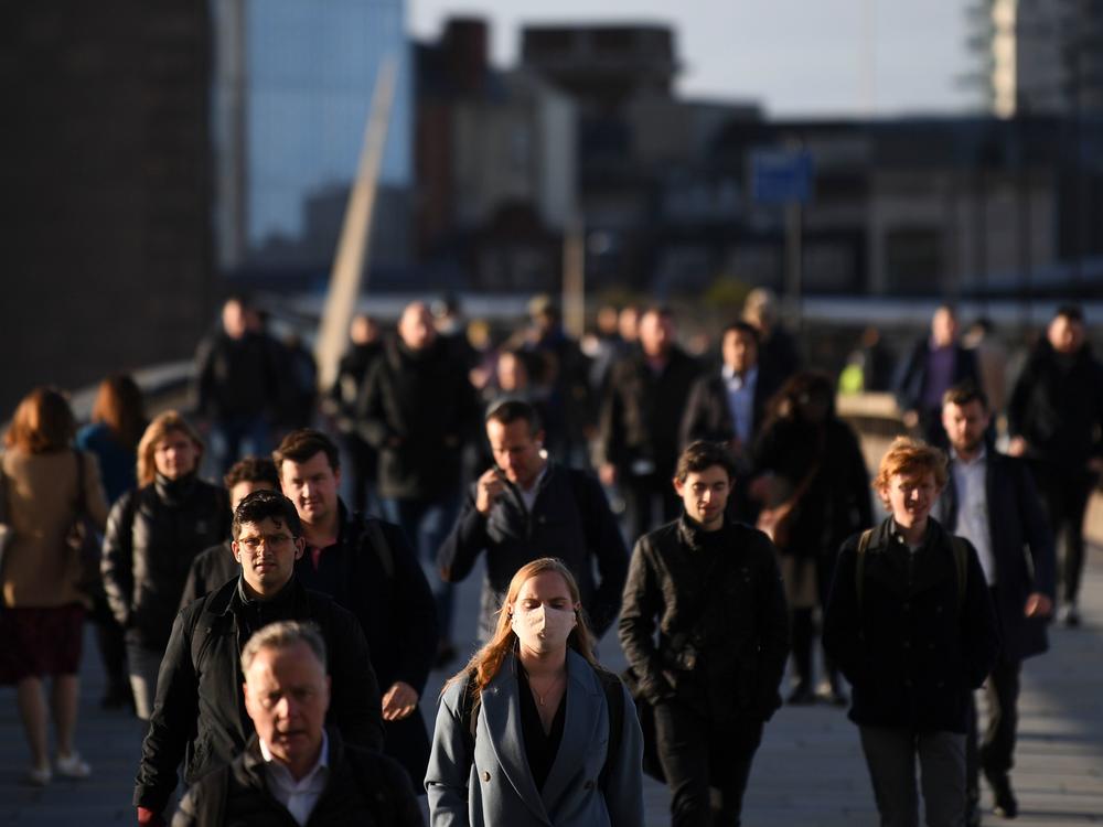 Commuters walk over London Bridge toward the city during the morning rush hour on Thursday. The city and other large areas are set to be under a high alert for the coronavirus.