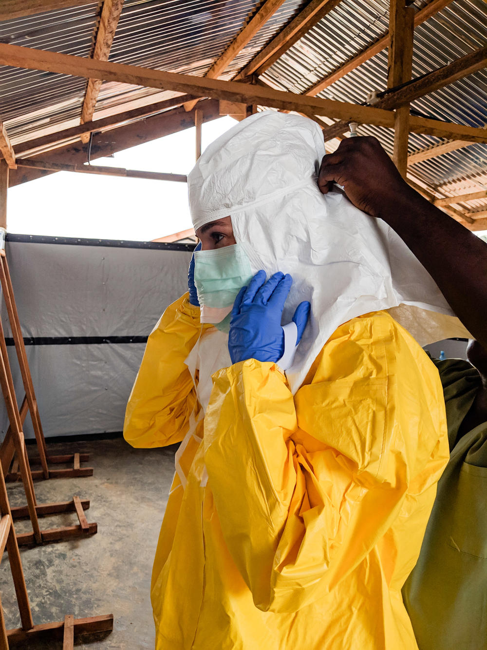 Karin Huster donning her protective gear in an Ebola ward, where medical teams tried to come up with ways to compensate for the lack of human touch.