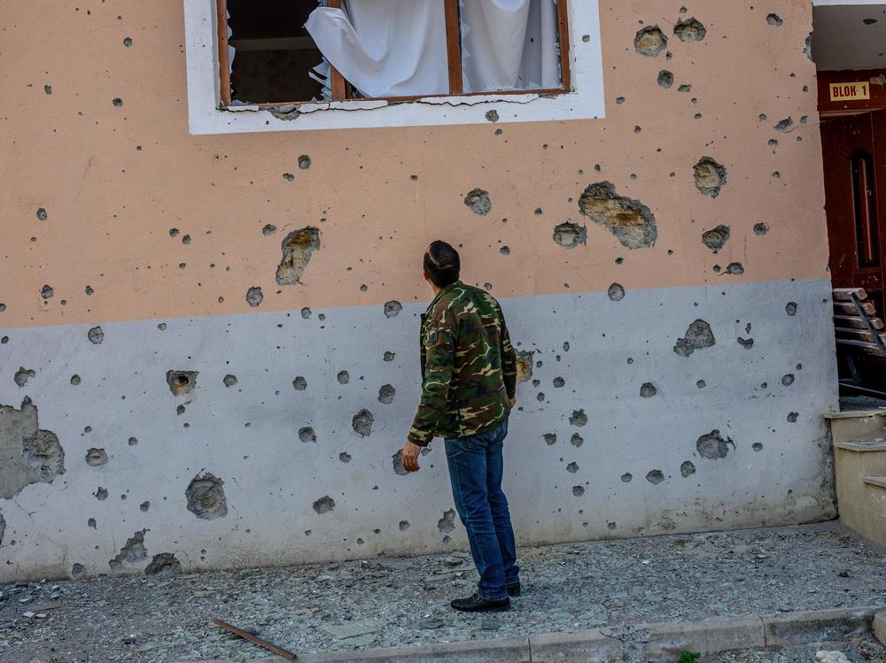 Movsumov Qowkar, 32, checks his neighbor's home damaged by shelling in the city of Terter early on Sunday.