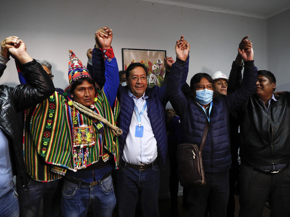 Bolivian presidential candidate Luis Arce (center) and running mate David Choquehuanca (second right) celebrate during a news conference Monday in La Paz, Bolivia.